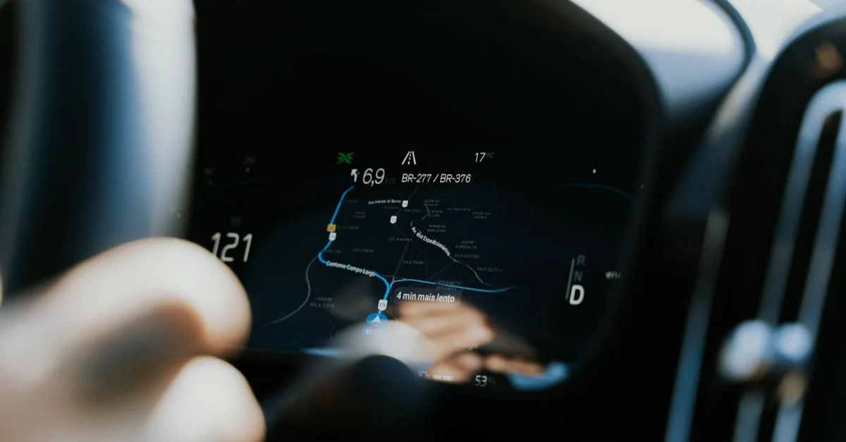 Vue rapprochée d'un tableau de bord de voiture affichant un écran de navigation GPS en utilisation.